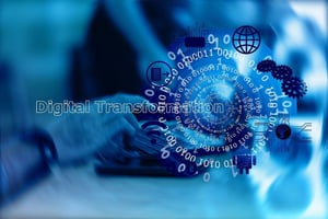 The words Digital Transformation shown over a blue overlay with a person working and binary numbers