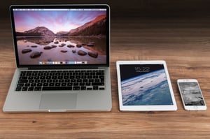 A laptop, tablet, and phone on a desk