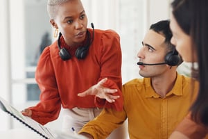 Telecom billing department members huddling at a desk